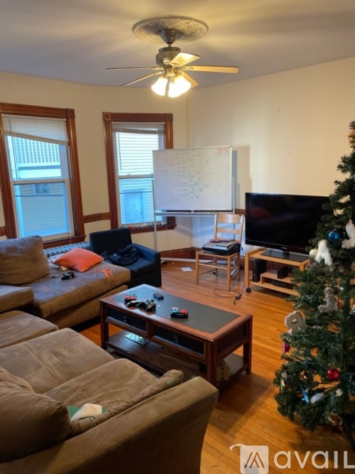 A living room with a Christmas tree and a whiteboard on the wall.