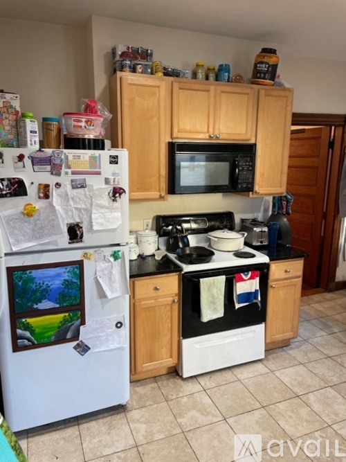 A kitchen with a white fridge and a black stove top.