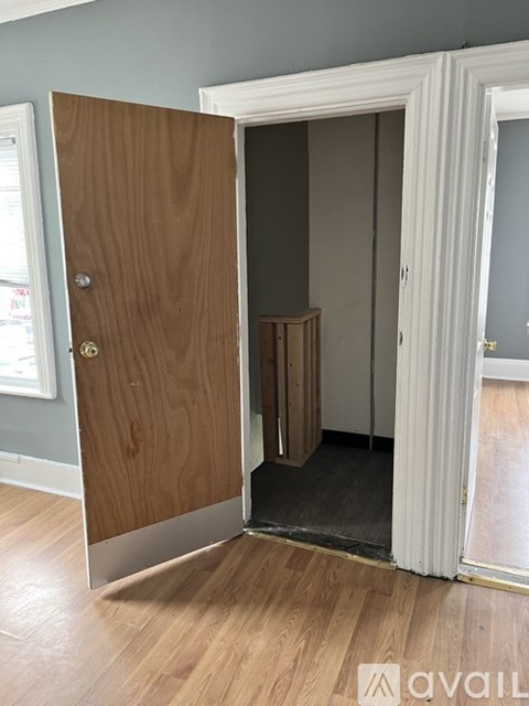 A room with a wooden door and a white frame.