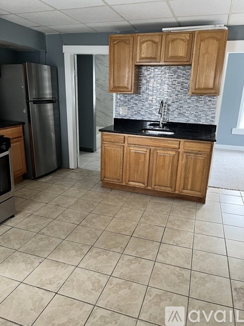 A kitchen with wooden cabinets and a black countertop.