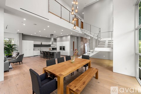 A modern open plan living and dining area with a wooden table and bench.