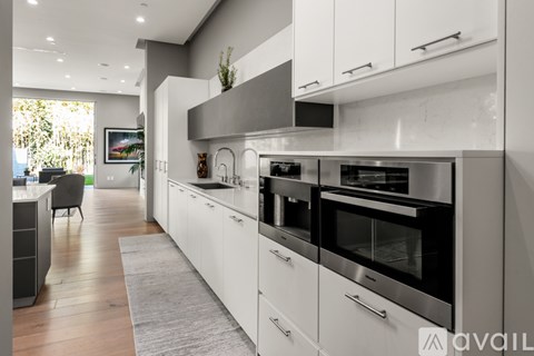 A modern kitchen with white cabinets and stainless steel appliances.