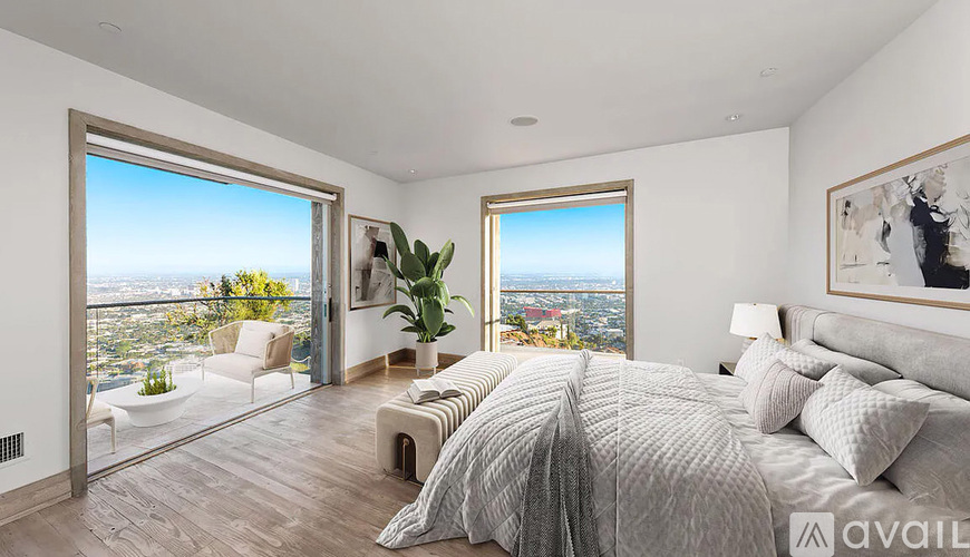 A bedroom with a large bed and a view of the city.