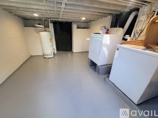 A large, empty industrial space with white walls and a grey floor.