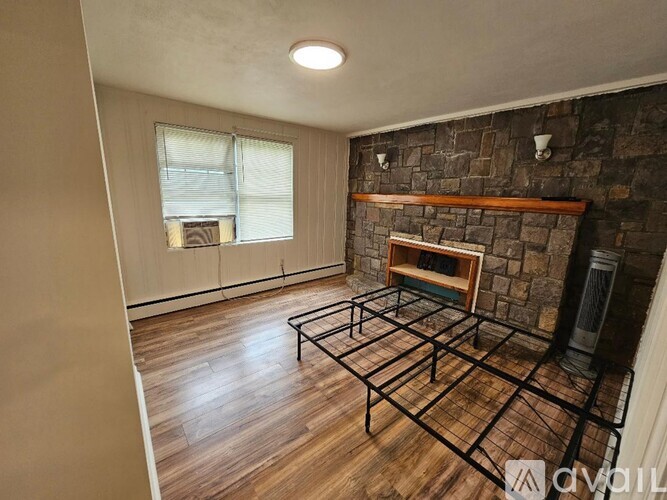 A living room with a fireplace and a large window.
