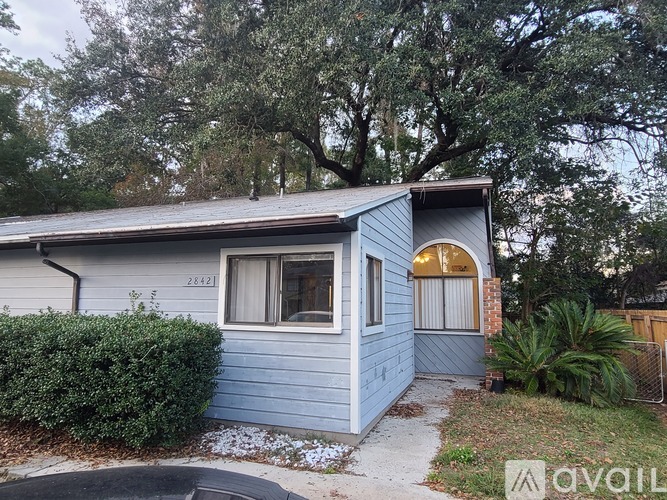 A blue house with a white window and a gold trimmed window.