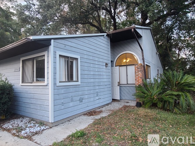 A small blue house with a brown roof and a white door.