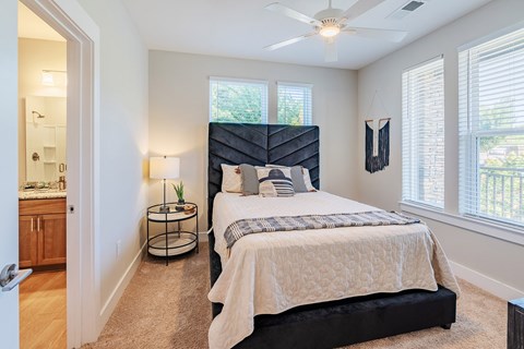 A bedroom with a large bed and a ceiling fan.