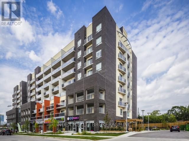 A large, modern apartment building with a sign that reads "REALTOR®" on the top left corner.
