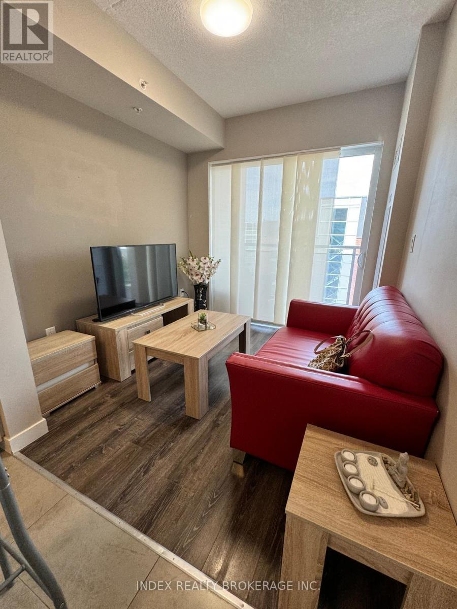 A living room with a red couch and a wooden coffee table.