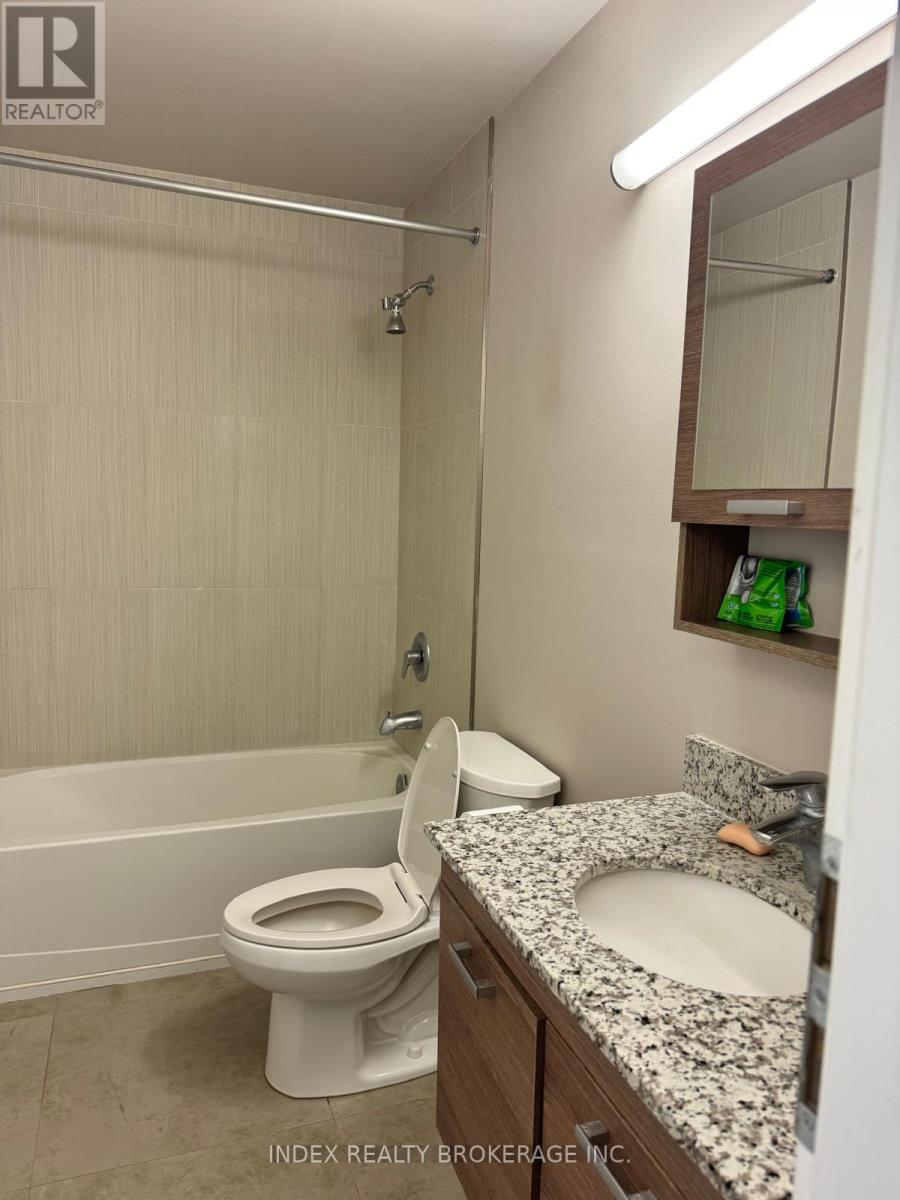 A white toilet sits in a bathroom next to a sink.