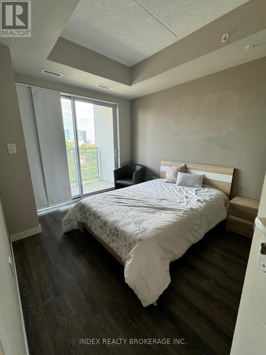 A bedroom with a bed, a chair, and a window.