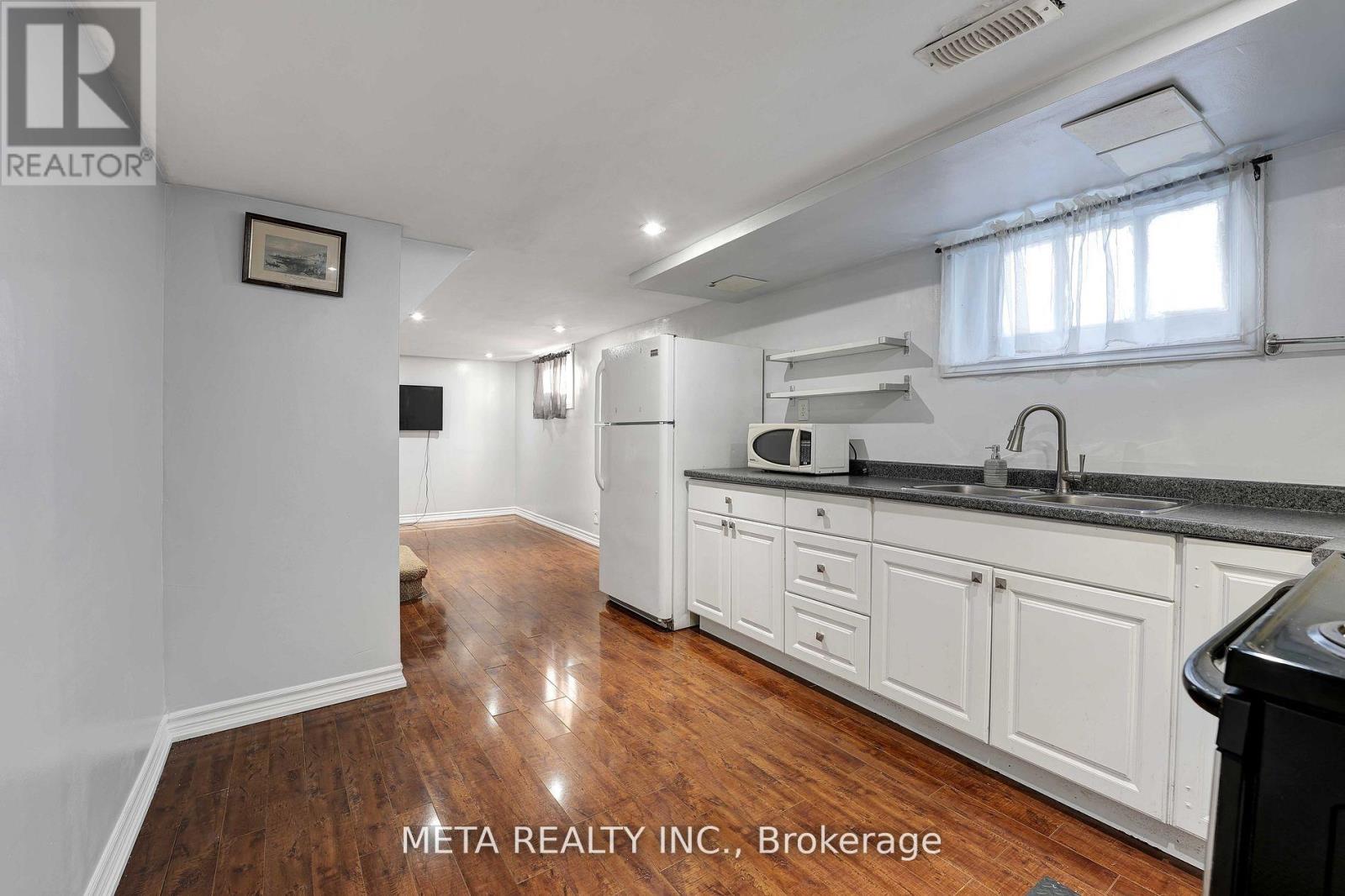 A kitchen with white cabinets and a black countertop.