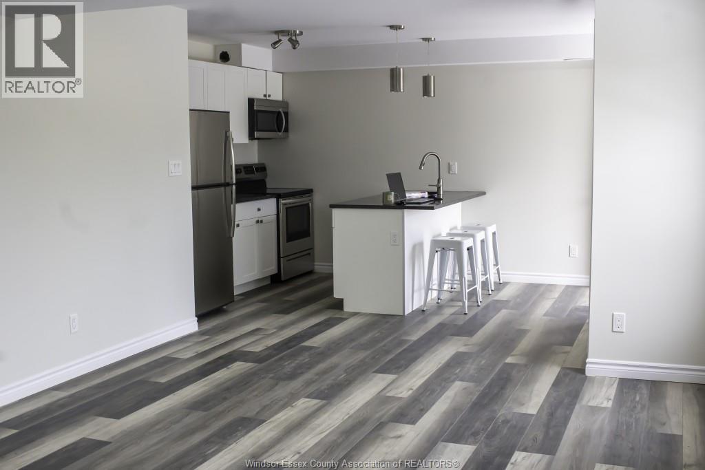 A kitchen with a refrigerator, microwave, and stove.