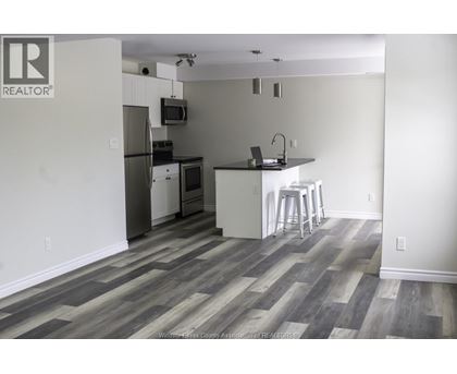 A kitchen with a refrigerator, microwave, and stove.