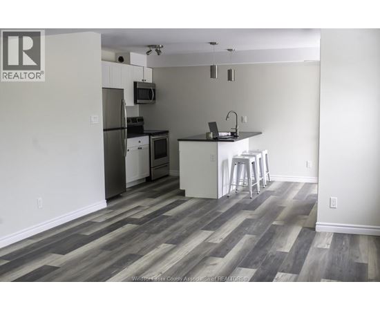 A kitchen with a refrigerator, microwave, and stove.