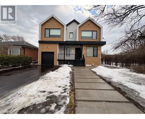 A modern two-story house with a black front door and a snow-covered sidewalk.