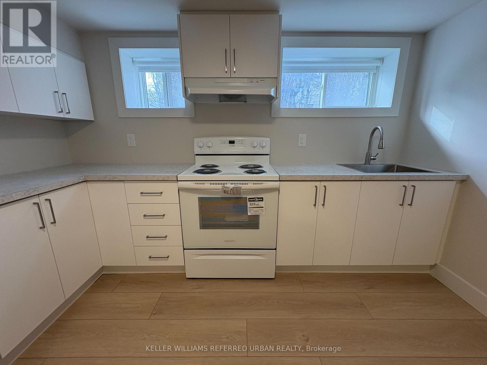 A kitchen with white cabinets and a stove top oven.