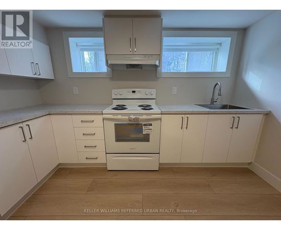 A kitchen with white cabinets and a stove top oven.