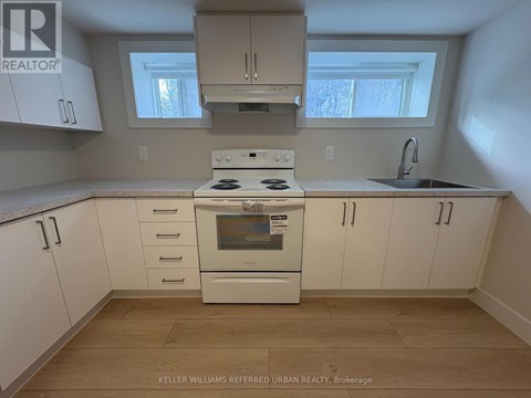 A kitchen with white cabinets and a stove top oven.