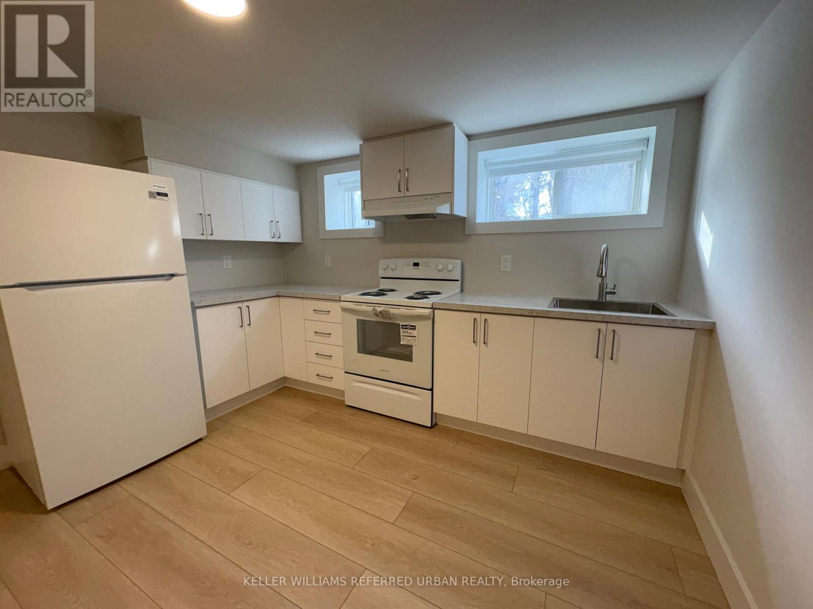 A kitchen with white appliances and cabinets.