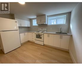 A kitchen with white appliances and cabinets.