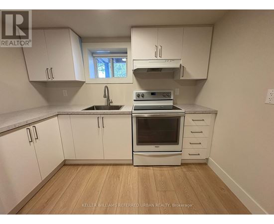A kitchen with white cabinets and a stove top oven.
