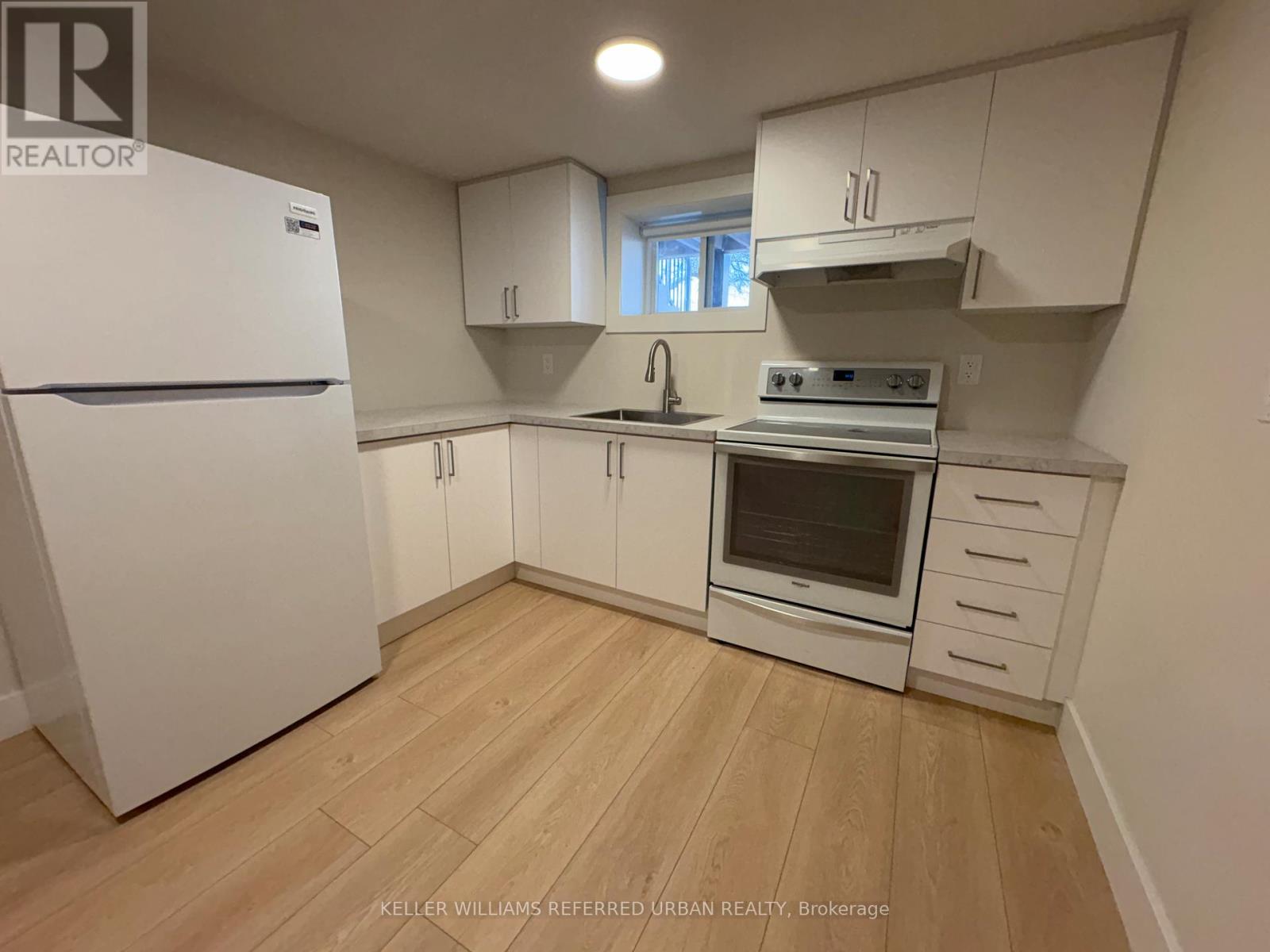 A kitchen with white appliances and cabinets.