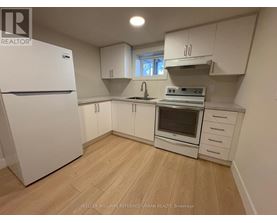 A kitchen with white appliances and cabinets.
