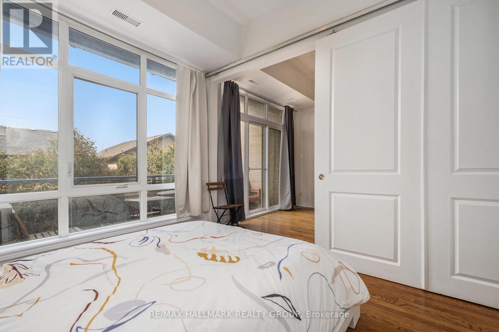 A bedroom with a large bed and a view of the outdoors through the window.
