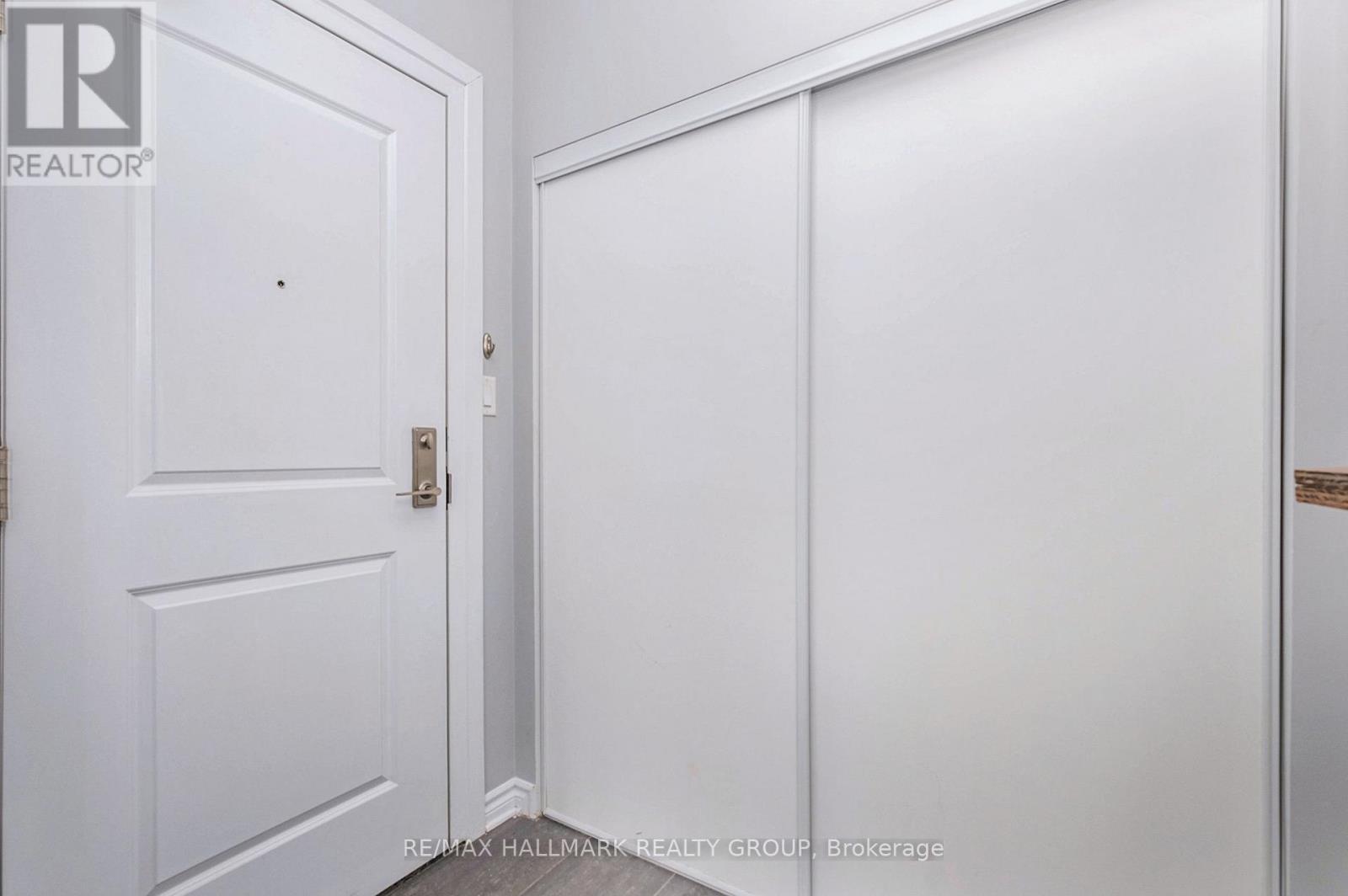 A white door with a handle and a white wall.