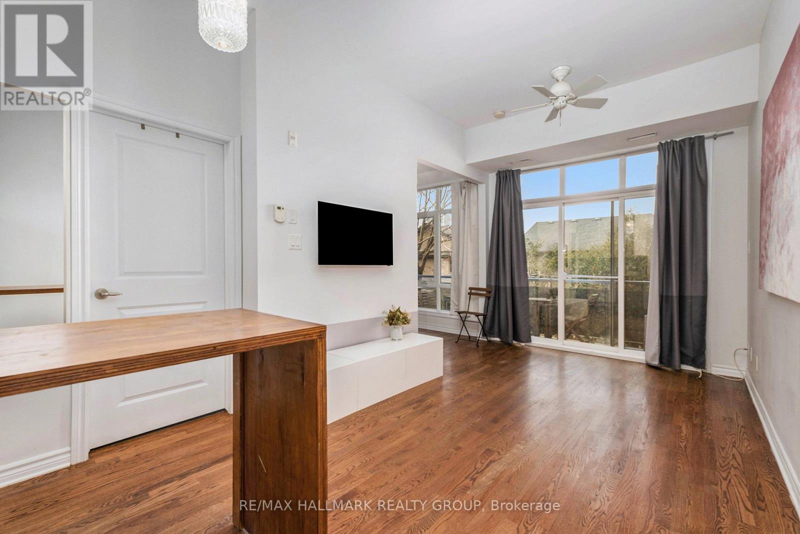 A living room with a flat screen TV mounted on the wall.