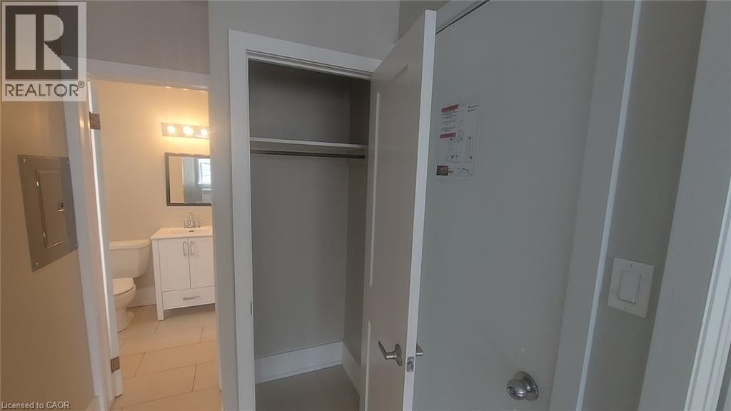 A bathroom with a toilet, sink, and a door leading to another room.