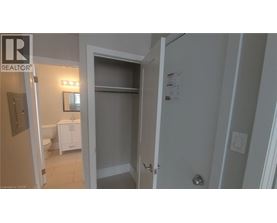 A bathroom with a toilet, sink, and a door leading to another room.