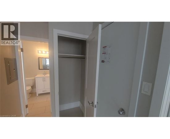A bathroom with a toilet, sink, and a door leading to another room.