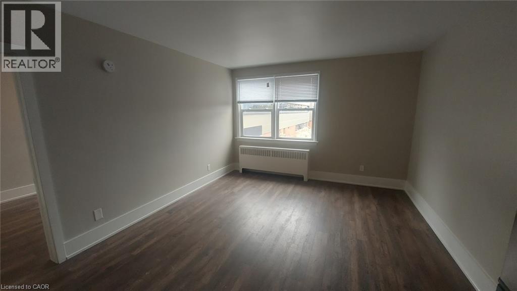 A room with wooden floors and a window with blinds.