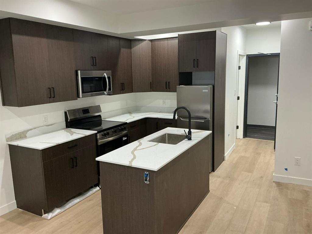 A kitchen with brown cabinets and a white counter top.