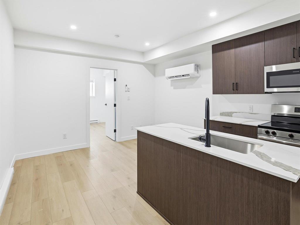 A white oven in a bathroom with a toilet and a black door.