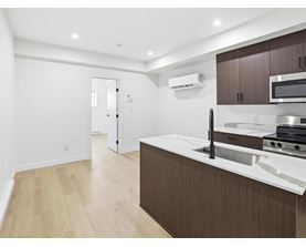 A white oven in a bathroom with a toilet and a black door.