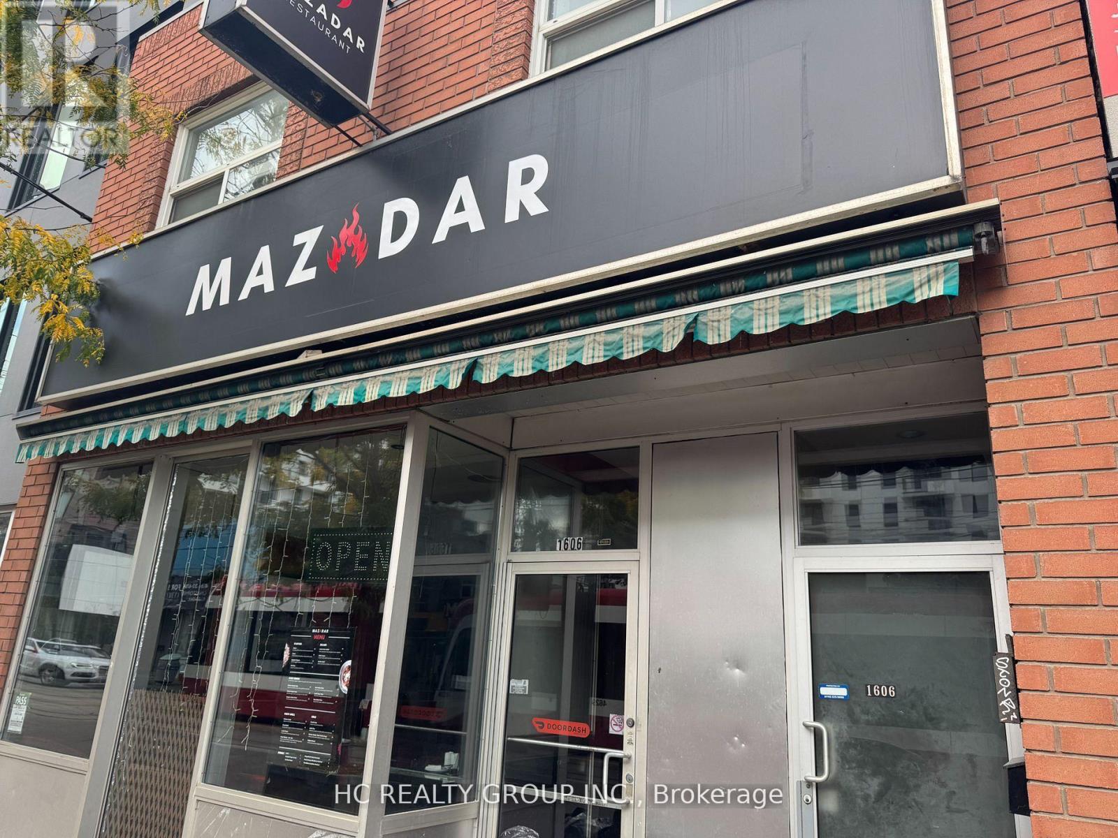 A Mazdar storefront with a black awning and glass windows.