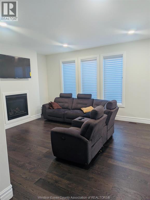 A living room with a grey couch and a fireplace.
