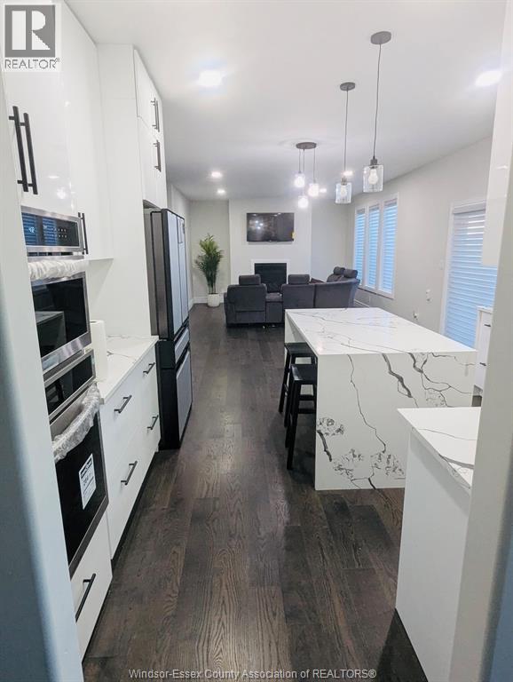 A kitchen with white cabinets and a black countertop.