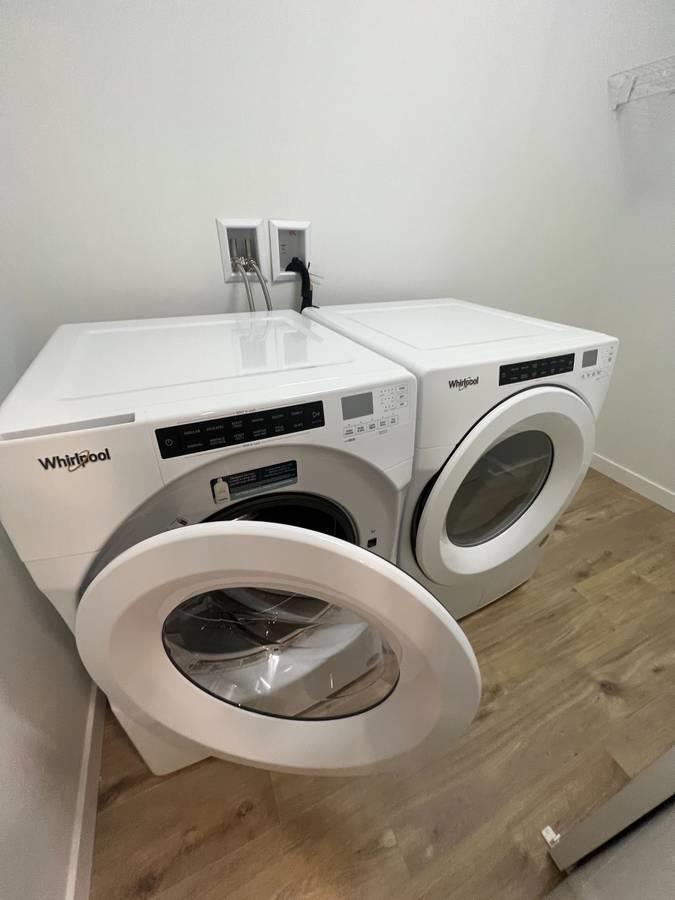 A Whirlpool washing machine and dryer in a laundry room.
