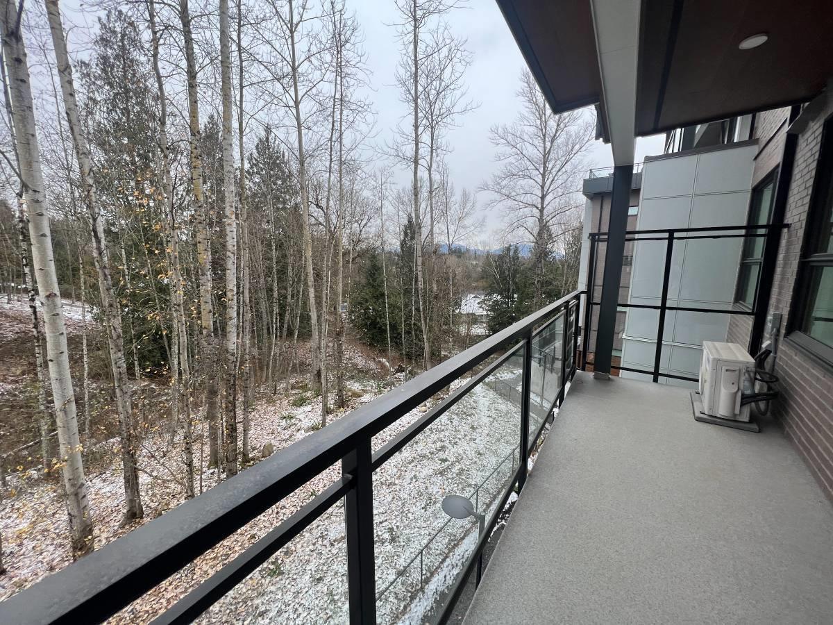 A snowy scene with a balcony and trees.