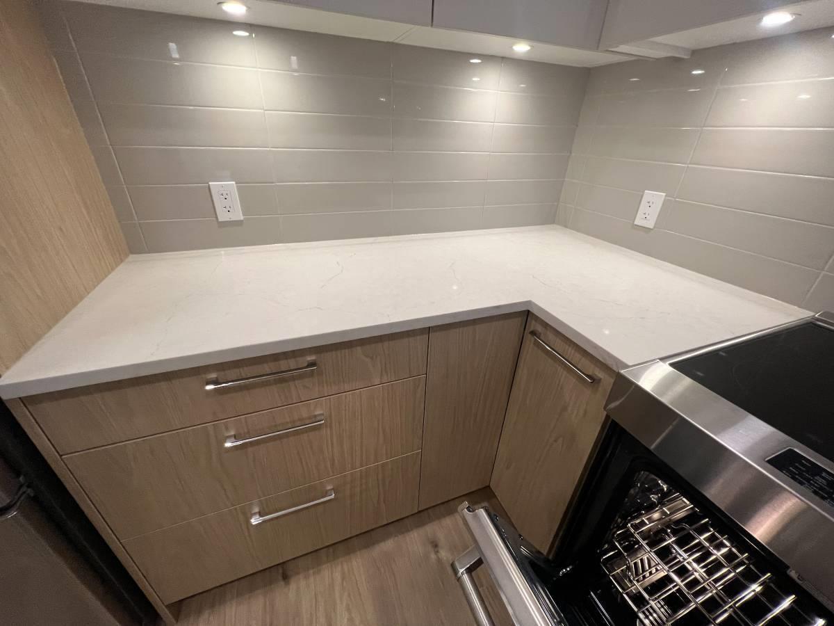 A kitchen with wooden cabinets and a stainless steel oven.