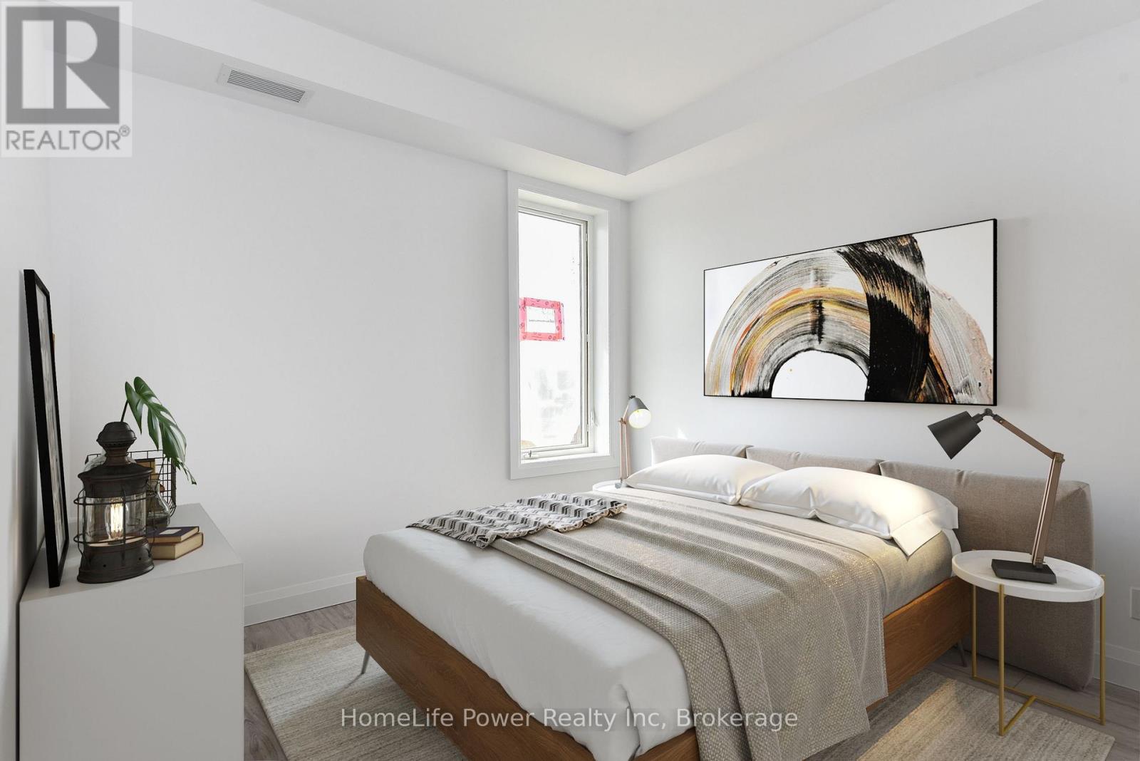 A bedroom with a bed, nightstand, and lamp.