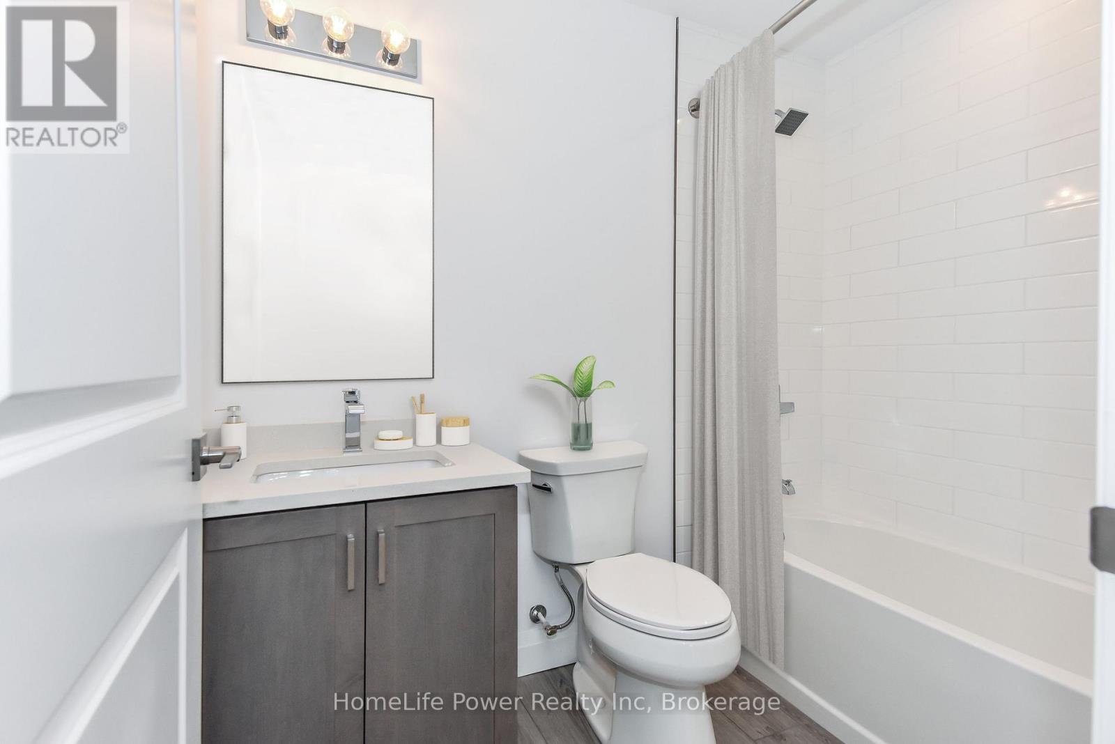 A white bathroom with a toilet, sink, and mirror.