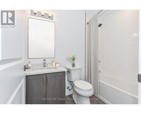 A white bathroom with a toilet, sink, and mirror.