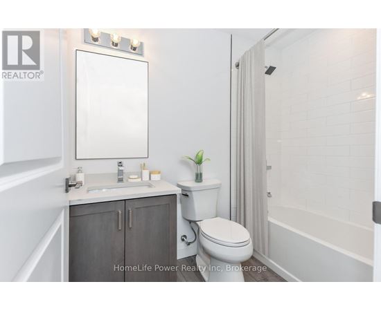 A white bathroom with a toilet, sink, and mirror.