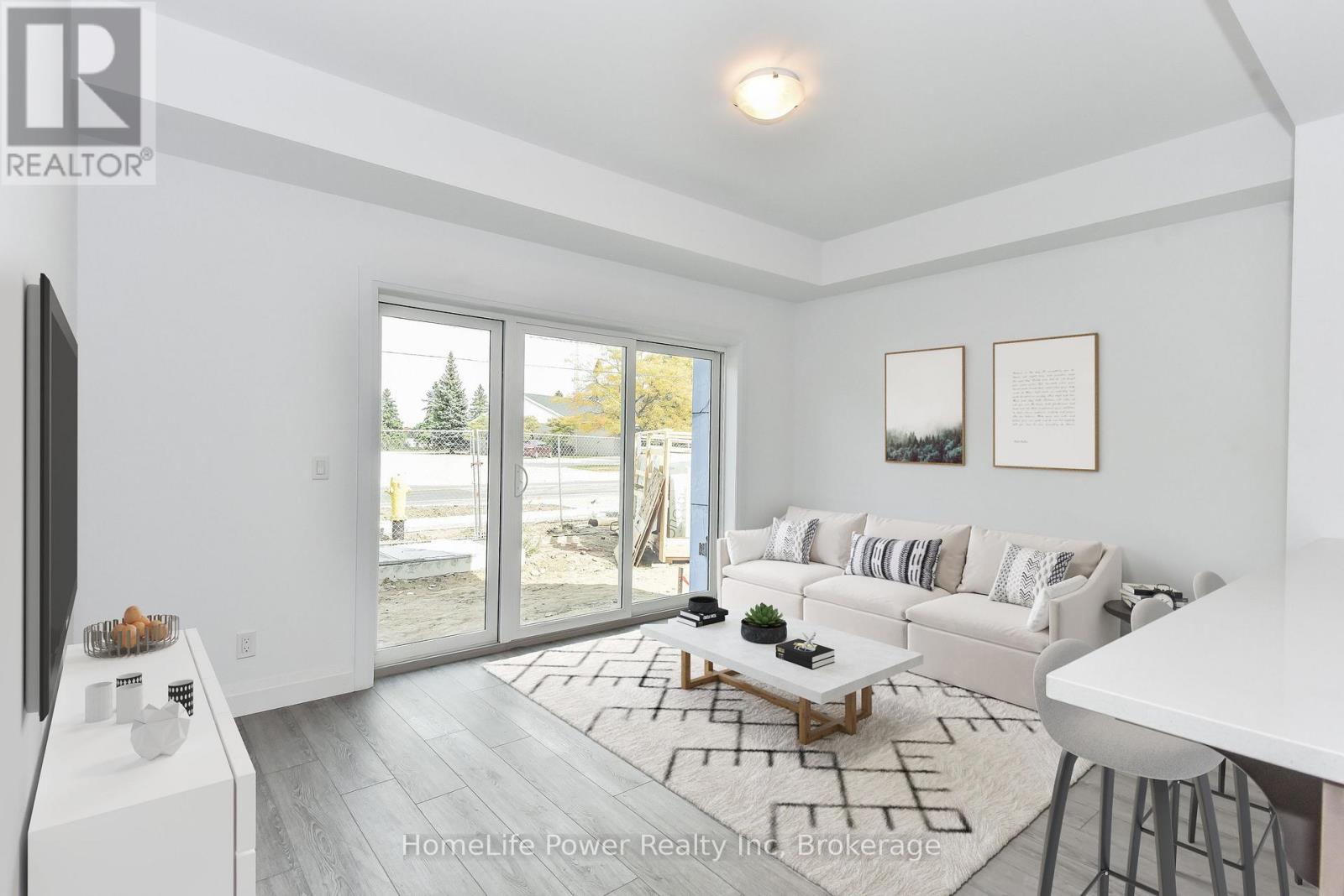 A modern living room with a flat screen TV and sliding glass doors.